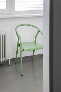 a green chair sitting in front of a radiator