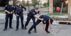 three police officers are trying to grab someone out of the street with their hands and feet