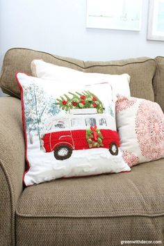 a couch with two pillows on it and a christmas tree hanging from the pillow case