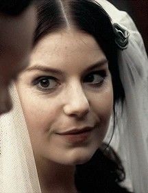 a close up of a person wearing a veil and looking at the camera with a smile on their face