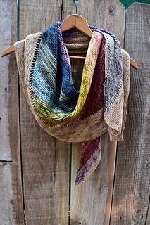 a multicolored scarf hanging on a wooden fence