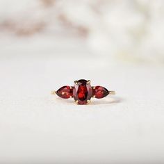 three stone ring sitting on top of a white surface