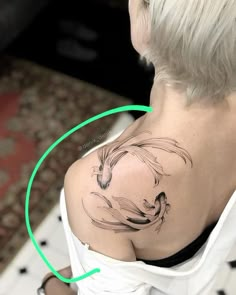 a woman with a tattoo on her shoulder has a green circle around her neck and there is an image of a horse in the background