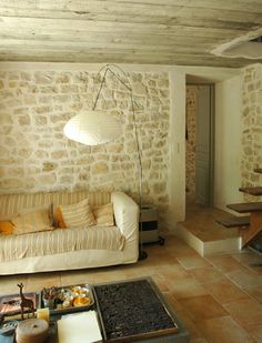 a living room filled with furniture and stone walls