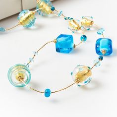 "Length: 88 cm / 34,64 \" Weight: 100 gr / 0,22 lb Classic tradition of this necklace is captured by the unique beads of different shapes: a succession of aquamarine glass squared and rounded beads, covered by precious gold leaf and \"sommerso\" in crystal, alternating with small spheres. The modern touch is given by the small crystals framing each bead, giving them additional light. This necklace, with its bright colours, is perfect for any style and fashion: its light composition makes it the Modern Polished Beads Necklace For Gift, Beaded Glass Long Necklace, Elegant Glass Necklaces With Large Beads, Elegant Glass Necklace With Large Beads, Long Glass Beaded Necklace With Polished Beads, Long Glass Beaded Necklaces With Polished Beads, Long Beaded Glass Necklace, Elegant Murano Glass Beaded Necklaces, Glass Large Beads Long Necklace