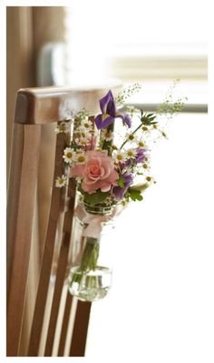 a bouquet of flowers sitting in a vase on a wooden chair next to a window