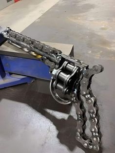 a close up of a metal object with chains on it's back end and two other objects in the background