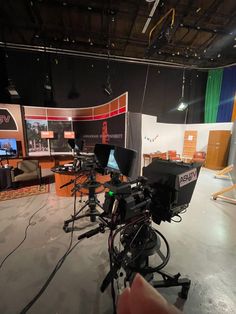 a camera set up in the middle of a room with two television sets on it