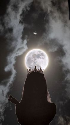 a person with a crown on their head looking up at the moon in the sky