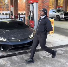 a man walking past a black sports car