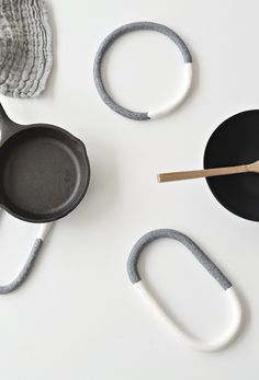 an assortment of kitchen utensils and accessories on a white counter top, including a cast iron skillet