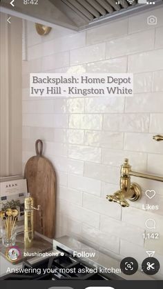 a kitchen with white tile and gold fixtures