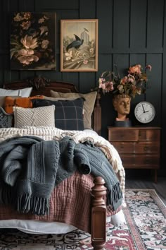 a bed with blankets and pillows on top of it next to a dresser in a bedroom