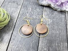 These lightweight dangle earrings feature 18mm dark brown unfinished wooden discs dangling inside 25mm gold plated brass hoops. The ear wires are made of hypoallergenic gold plated surgical steel, making these earrings safe for sensitive ears! They are super lightweight, each weighing only 0.1 ounce. They measure approximately 1.75 inches from the top of the ear wires to the bottom of the gold hoop.Domestic shipping is always free here at Mayamadethis!When will my item ship? Every single item he Wooden Round Earrings For Gifts, Round Wooden Earrings For Gifts, Round Wooden Earrings As Gift, Wooden Round Earrings Gift, Handmade Round Wooden Earrings, Handmade Wooden Round Earrings, Hypoallergenic Brown Round Earrings, Brown Wooden Beads Round Earrings, Everyday Hypoallergenic Brown Earrings