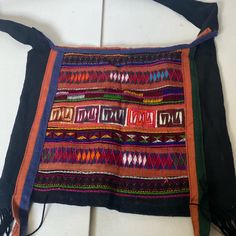 an old, colorful purse with tassels on it