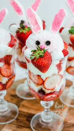 some strawberries and other desserts are arranged in small glasses with bunny ears on them