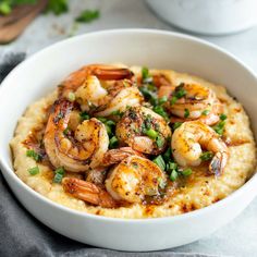 a white bowl filled with gritee topped with shrimp