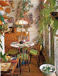 a room filled with lots of furniture and plants on the wall next to a window