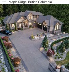 an aerial view of a large home with driveway and landscaping at night, taken from above