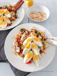 two white plates filled with food on top of a table