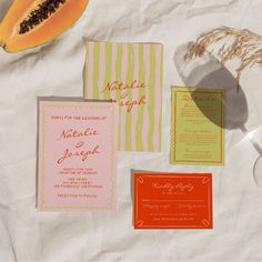 the wedding stationery is laid out on top of the table with fruit and paper