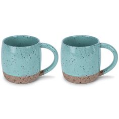 two coffee mugs sitting next to each other on a white surface with speckles