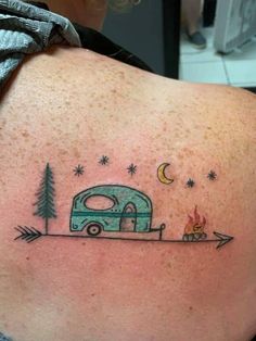 a woman's back with an rv and trees tattoo on her left side shoulder