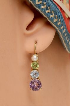 Wear this heavenly array of stones and create your own grand occasion. Crafted by hand, an amethyst, blue topaz, peridot and cultured pearl are set in 14k gold settings. European backs for pierced ears. 1 1/4 inches tall. Luxury Peridot Earrings For May Birthstone, Gold Peridot Earrings For May Birthstone, Round Peridot Gemstone Earrings, Peridot Gemstone Drop Earrings, Peridot Gemstone Dangle Earrings, Christina Rossetti, Peridot Earrings, Hand Made Jewelry, Pierced Ears