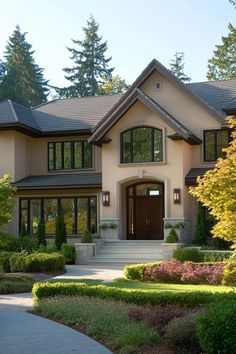 a large house with lots of windows and landscaping around it's front entrance area