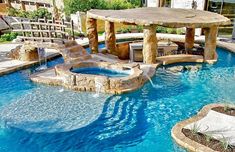 an outdoor swimming pool with waterfall and seating area