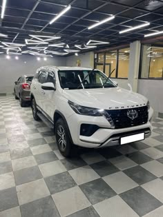 two white trucks are parked in a garage