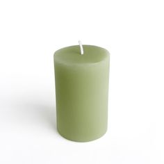 a green candle with a white top on a white background