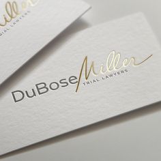 two business cards with gold lettering on them