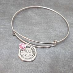 High-quality stainless steel bangle with initial pendant and Swarovski crystal birthstone of your choice!  Thick wire silver bangle is adjustable for any wrist size and super comfortable.  A classic look for everyday wear. This is an AMAZING deal!! Wonderful gift for birthdays, Valentine's, bridesmaids, new mothers, etc. Each bracelet comes with a free gift box.  Initial charms are in the style of antique wax seals used to close envelopes or love letters.   The wax seal pendant is silver plated Monogram Metal Jewelry For Gifts, Silver Monogram Bracelet With Adjustable Fit, Silver Adjustable Monogram Bracelet, Adjustable Silver Monogram Bracelet, Nickel Free Adjustable Initial Pendant Jewelry, Adjustable Nickel Free Initial Pendant Jewelry, Silver Metal Jewelry With Initials, Personalized Monogram Adjustable Jewelry, Adjustable Silver Monogram Jewelry