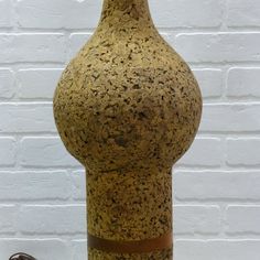 a brown vase sitting next to a white brick wall