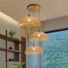 three lights hanging from the ceiling above a dining room table and chairs in front of a window