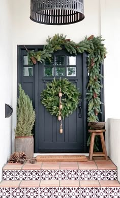 the front door is decorated with wreaths and pine cones