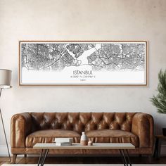 a living room with a leather couch and coffee table in front of a framed map