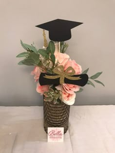 a vase with flowers and a graduation cap on top