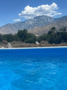 an empty swimming pool with mountains in the background