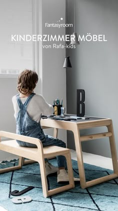 a young child sitting at a desk with the words kinderzimer mobel on it