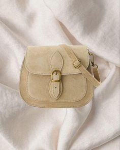 Our Suede Bag Saffron is the perfect sized every day handbag and an updated classic for every wardrobe. All leather, this to-go piece features a fold over top with a magnet closure and a discrete internal zip pocket. The adjustable, detachable suede strap allows you to wear it short or long, across the body or on the shoulder. Use it to hold your phone and wallet when dashing up the street for coffee or pair it with a floaty dress and fine jewels for a lunch date. This bag is a great statement p Beige Satchel Shoulder Bag With Hasp Closure, Beige Satchel Flap Bag With Phone Pocket, Beige Satchel Flap Bag With Phone Holder, Beige Top Handle Satchel With Hasp Closure, Beige Rectangular Satchel With Hasp Closure, Rectangular Beige Satchel With Hasp Closure, Beige Pouch Satchel For Daily Use, Beige Bag With Detachable Strap For Gift, Cream Satchel With Mobile Phone Bag For Daily Use