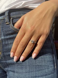 a woman's hand with a diamond ring on her left wrist, in jeans