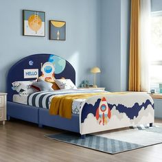 a bedroom with blue walls and a rocket ship bed frame in the center, along with two nightstands on either side