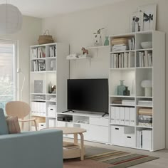 a living room filled with furniture and a flat screen tv mounted on a wall next to a window