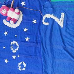 a blue blanket with white stars and a pink teddy bear on it