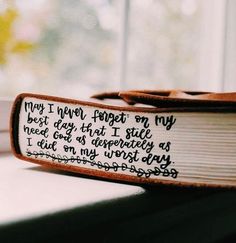 an open book with writing on it sitting on a window sill next to a window