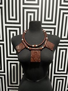 This necklace is crafted with genuine leather from Mali. Unisex and handmade, each piece is one-of-a-kind and may have slight imperfections due to the manufacturing process. Layer it with other necklaces to create a unique look. Bohemian Leather Pendant Necklace, Brown Artisan Necklace With Large Pendant, Artisan Brown Necklace With Large Pendant, Brown Leather Pendant Necklace, Vintage Leather Necklace As Gift, Vintage Leather Necklace For Gift, Unique Adjustable Brown Necklace, Vintage Adjustable Leather Necklace, Adjustable Leather Vintage Necklace