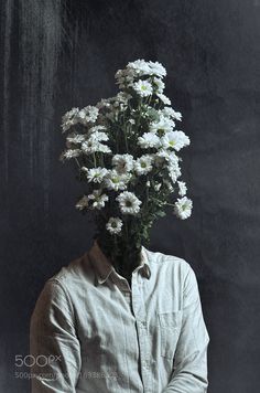 a man with flowers on his head in front of him