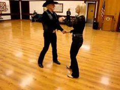 two people are dancing on a wooden floor